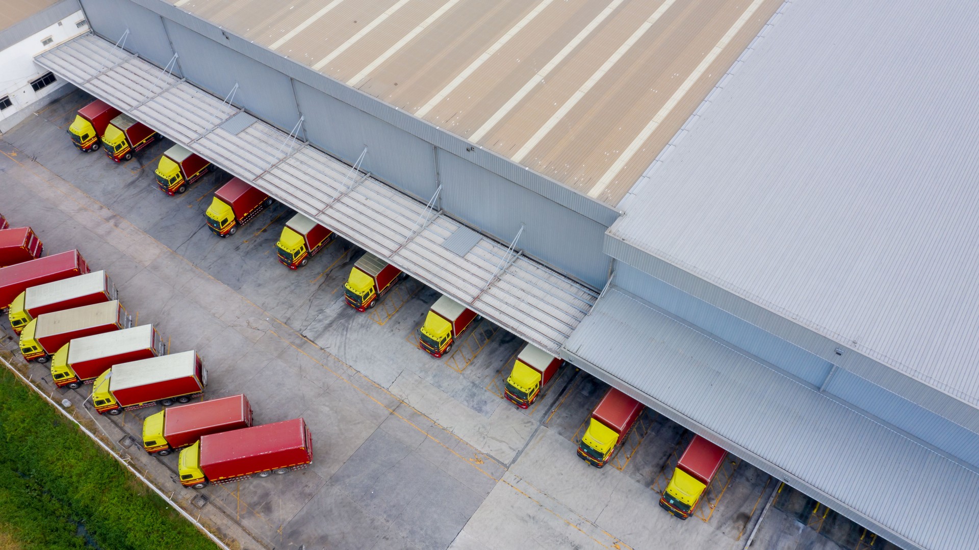 Centre logistique de vue aérienne dans la ville industrielle, dock industriel de chargement d’entrepôt où beaucoup de camion avec des remorques semi-remorques chargent des marchandises, Camions chargeant à l’entrepôt de marchandises de centre logi